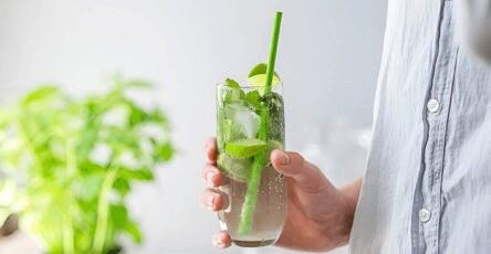 Image of a man holding a glass of Delta-9 drink in his hand.