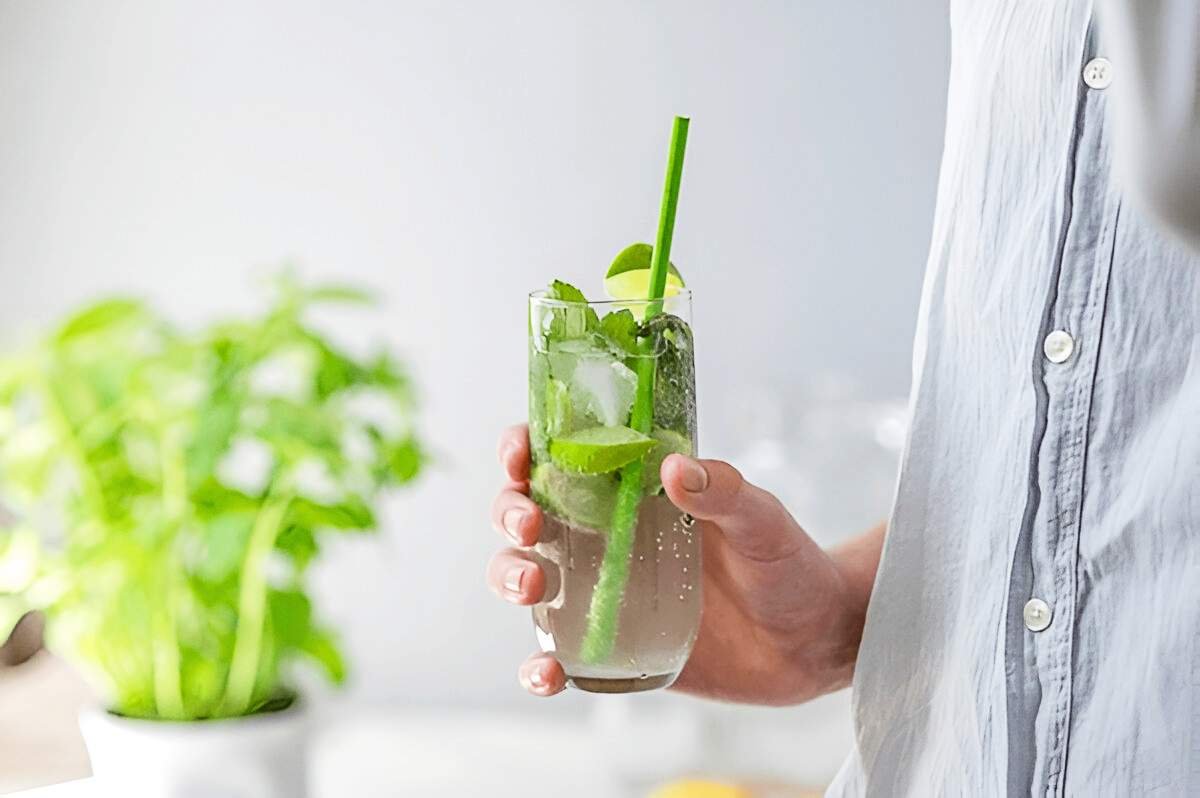 Image of a man holding a glass of Delta-9 drink in his hand.